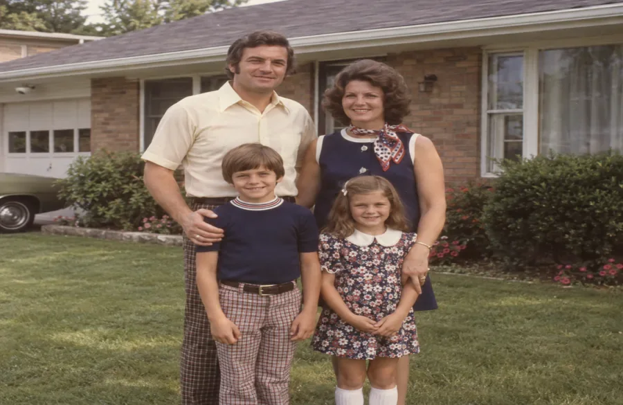 The same scanned family photo after AI restoration with brighter color and sharper faces