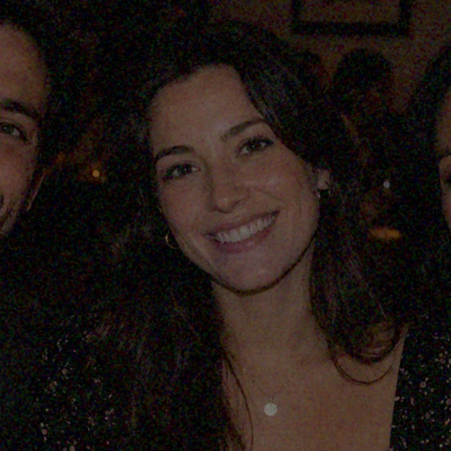 Dark photo of friends at a dinner table as captured in dim light, with noise hidden in the shadows