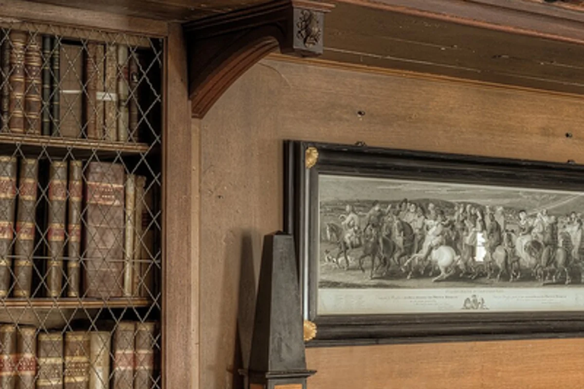 Full HD version of a library close-up scaled to 4K: book spines and the caption under a framed engraving are blurry
