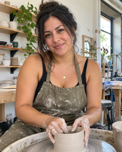 AI dating photo of a woman at a pottery wheel in a studio