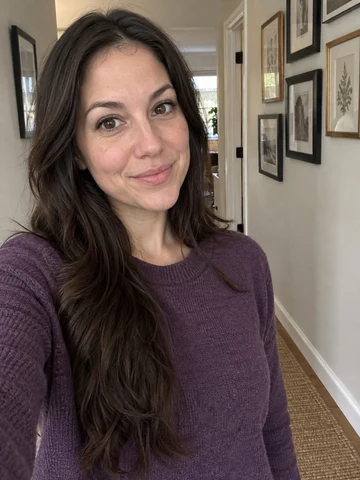 Drag to compare a casual photo in a purple sweater with the AI headshot in a black blazer (before)
