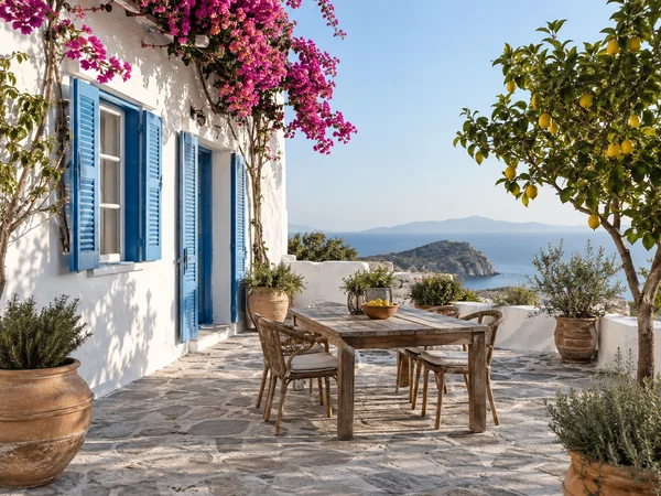 Whitewashed Greek island patio with blue shutters, bougainvillea, and a lemon tree