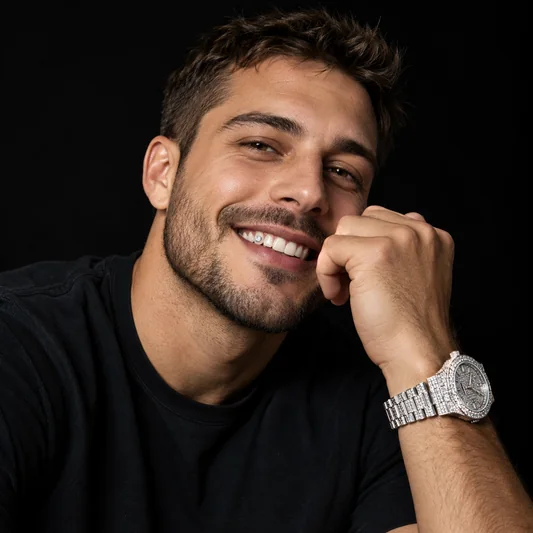 Smiling man in a dark studio with diamond grillz and an iced-out watch held to his face