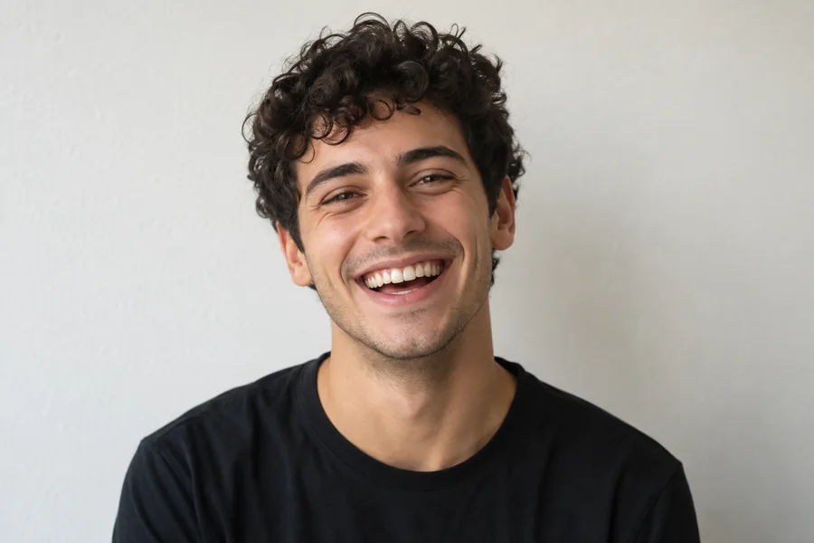 Drag to compare the smiling portrait before and after the buzz cut filter (before)