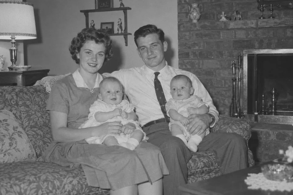 Drag to compare the black and white 1950s family on a sofa and the colorized photo (before)
