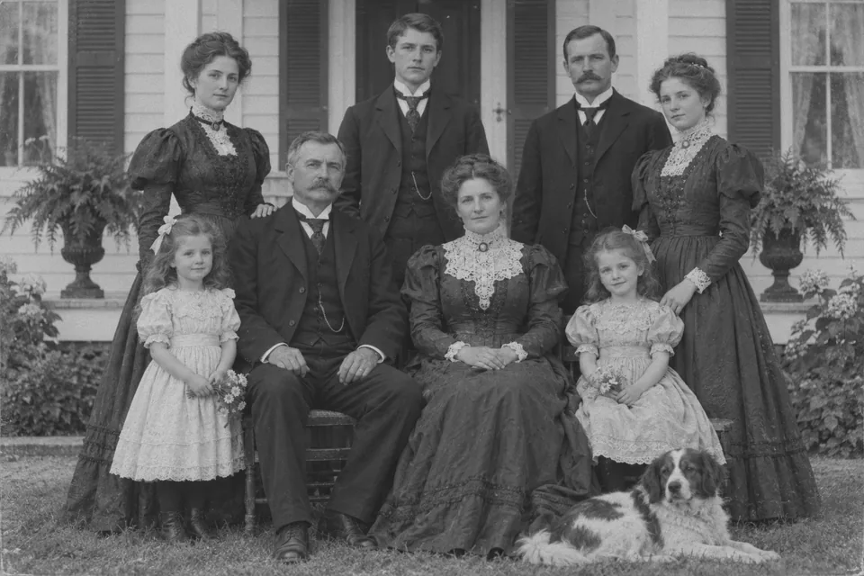 Drag to compare the black and white Victorian family portrait and the colorized version (before)