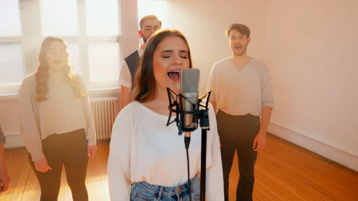 Start frame for Kling 2.6 image to video: a singer and her band in a bright rehearsal room before the clip begins