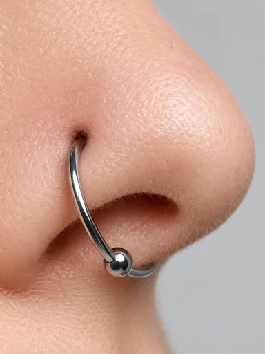 Close-up of a silver captive bead ring in a nostril
