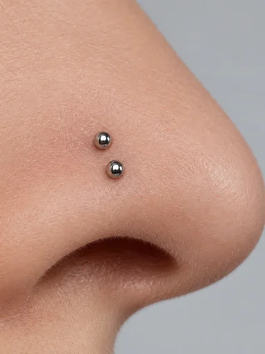 Close-up of two small studs stacked on one nostril
