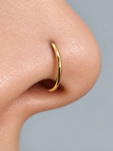 Close-up of a thin gold hoop in a nostril