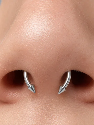 Close-up of a septum horseshoe with spiked ends