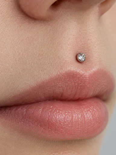Close-up of a medusa stud above the upper lip