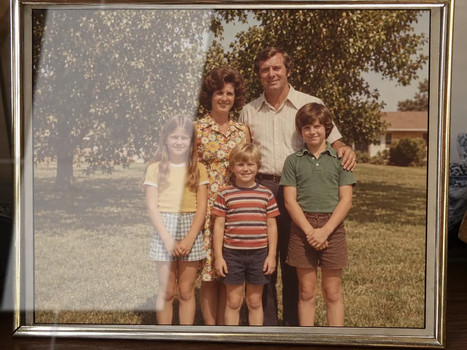 Drag to compare the framed family photo with window reflections and the cleaned photo (before)
