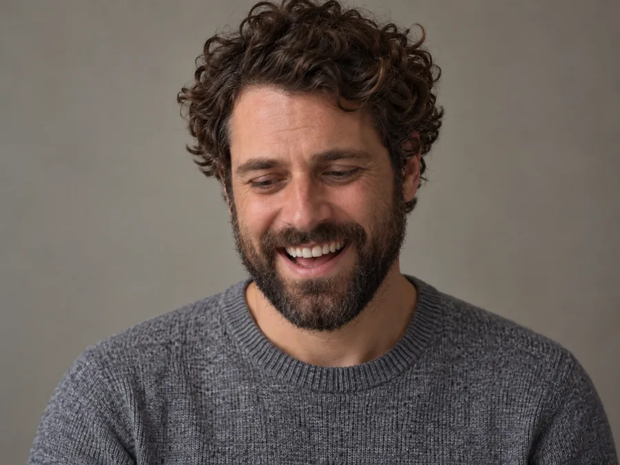 Drag to compare the downcast bearded man and the big grin (after)